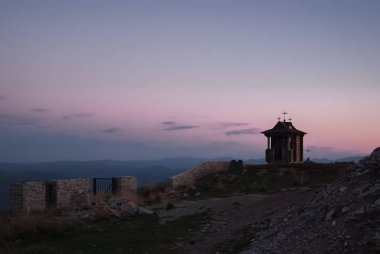 Güneşli bir günde dağlar ve bulutlar ve iğne yapraklı orman ile gün batımı. Manzara