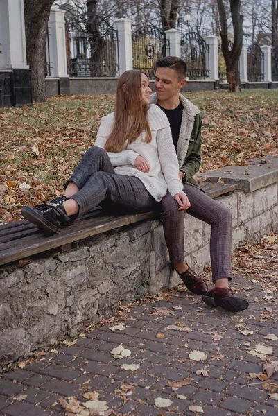 คู่รักที่มีความสุขเดินในวันฤดูใบไม้ร่วงในสวนสาธารณะ พวกเขากําลังสนุกด้วยกัน น่ารัก วัยรุ่น — ภาพถ่ายสต็อก