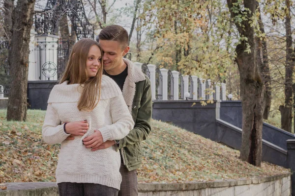 Glückliches junges Paar, das an einem Herbsttag im Park spazieren geht. Niedlicher Teenager — Stockfoto