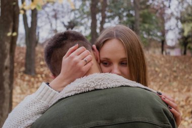 Parkta bir sonbahar gününde yürüyüş mutlu genç çift. Birlikte eğleniyorlar. Sevimli Genç