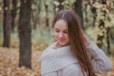 Renkli sonbahar yaprakları yakın beyaz kazak güzel bir kız portresi yakın. Romantik bir kadının eseri. Pretty hassasiyet modeli gülümseyen