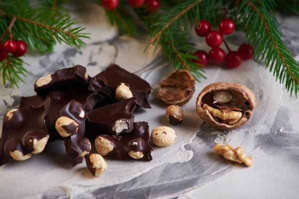 Gray background with sweets, candies, nuts, cookies and hollyberry