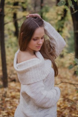 Örme kazak sonbahar uzun dalgalı saçlar ile güzel, rüya ve mutlu bir kız portresi. Güzel hava