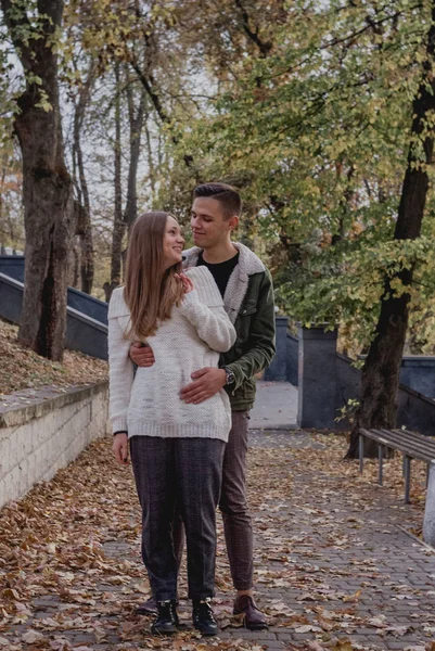 Feliz casal jovem andando em um dia de outono no parque. Eles estão se divertindo juntos. adolescente bonito — Fotografia de Stock