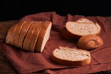 Fırın ekmek üreticileri - altın rustik huysuz somun ekmek ve siyah kara tahta zemin üzerine buns. Natürmort yukarıdan yakalanan