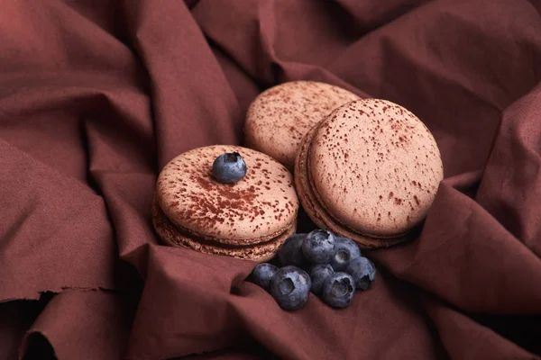 Свежие и вкусные черничные ягоды с шоколадными макаронами на ткани — стоковое фото