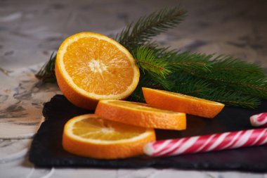 Taze slised portakal ve gri arka plan üzerinde şeker ve ladin dalı ile