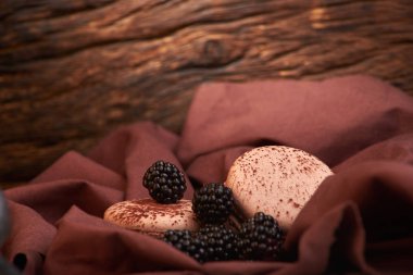 kumaş üzerine çikolata makarna ile taze ve lezzetli böğürtlen. Tatlı