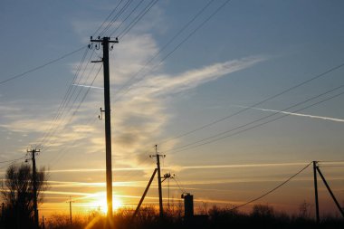 Gün batımını arka plan üzerinde enerji hatları