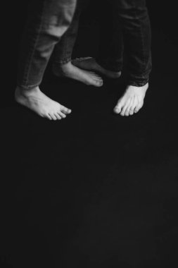 Siyah beyaz fotoğraf çekimi, aşk hikayesi, aşıklar, siyah arka plandaki erkek ve kadın, vücut detayları.