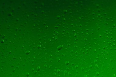 Pencere camındaki yağmur damlaları, penceredeki buğulanma, yeşil arkaplan