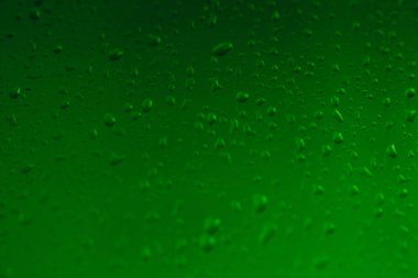 Pencere camındaki yağmur damlaları, penceredeki buğulanma, yeşil arkaplan