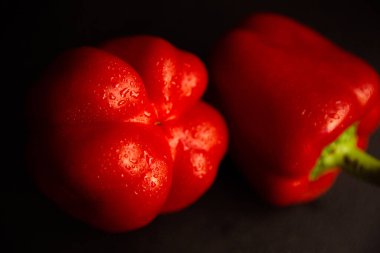 Taze sebzeler, siyah arka planda kırmızı biberler.