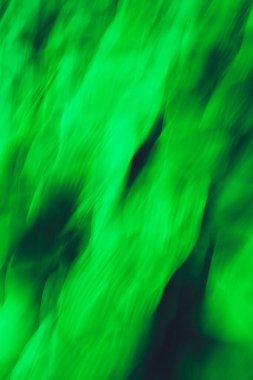 Dokulu hareket bulanıklığı, uzun süre yeşil bitki ve çiçeklere maruz kalma. Yeşil soyut girdaplı kaleydoskop deseni.