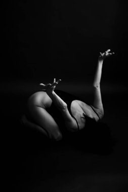 Bir kişinin siyah beyaz fotoğrafı, stüdyoda poz veren bir dansçı, vücudun parçaları, sanat ve moda