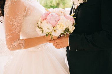 Gelin ve damat el ele tutuşuyorlar.