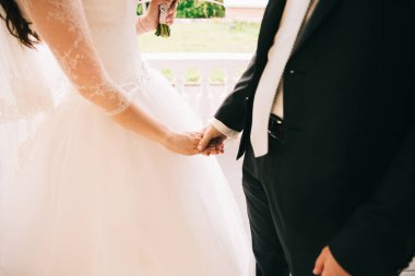 Gelin ve damat el ele tutuşuyorlar.