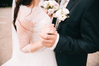 Gelin ve damat el ele tutuşuyorlar.