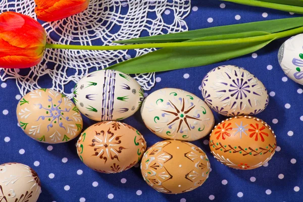 Ovos de Páscoa e tulipa na toalha de mesa azul — Fotografia de Stock