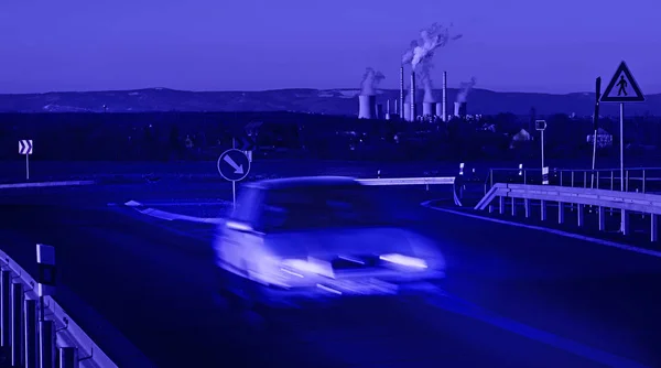 Samochód jadący przed Elektrownia w nocy — Zdjęcie stockowe