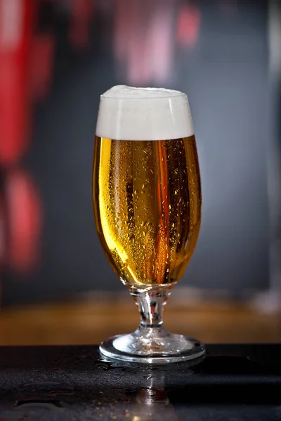 Glas bier op de donkere achtergrond — Stockfoto