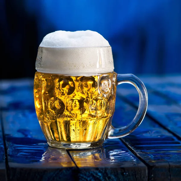 Glas öl på blå trä bakgrund. — Stockfoto