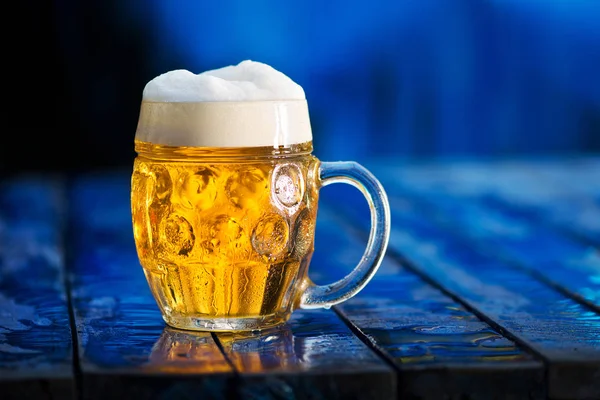 Glas Bier auf blauem Holzgrund. Stockfoto