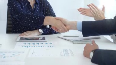 Business people shaking hands, colleagues clapping after sealing significant partnership, expressing professional success and collaborative achievement. Handshake at meeting.