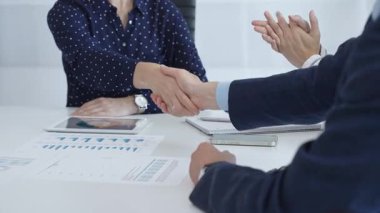 Business people shaking hands, colleagues clapping after sealing significant partnership, expressing professional success and collaborative achievement. Handshake at meeting.