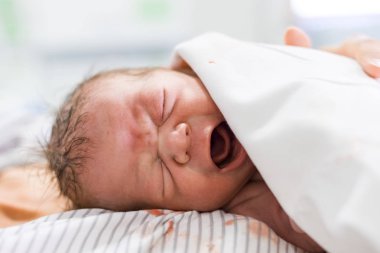 Yeni doğan bebek çocuk annesinin göğsüne ağlıyor