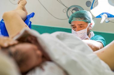 Faro, Portekiz - 7 Mayıs 2018: Doktor ve şirin yeni doğan bebek çocuk sadece ön planda Doğum sonrası