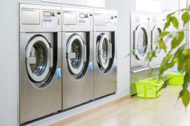Üst üste modern, gümüş çamaşır makineleri ile ortak Çamaşırhane
