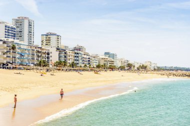 Modern Quarteira içinde sahil boyunca güneşli gün boyunca, Algarve, Portekiz yürüyüş insanlar