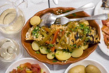 Kırmızı ve yeşil biber ile geleneksel Portekiz altın balık pişmiş patates ve domates salatası ile servis