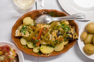 Kırmızı ve yeşil biber ile geleneksel Portekiz altın balık pişmiş patates ve domates salatası ile servis