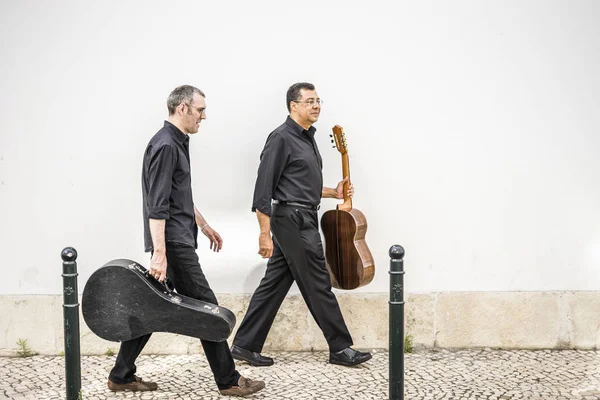 Twee Gitaristen Wandelen Met Hun Instrumenten Stoep Door Witte Muur — Stockfoto