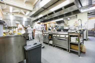 Mutfak personeli restoranda öğle yemeği zamanı sırasında gıda hazırlama ile meşgul