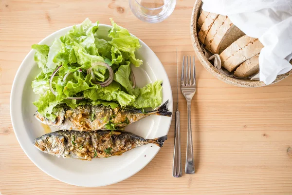 两份新鲜烤沙丁鱼 配生菜沙拉和面包 — 图库照片