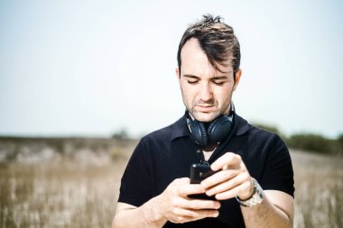 Çalma listesi smartphone üzerinde ayarlama kulaklık ile şık genç adam