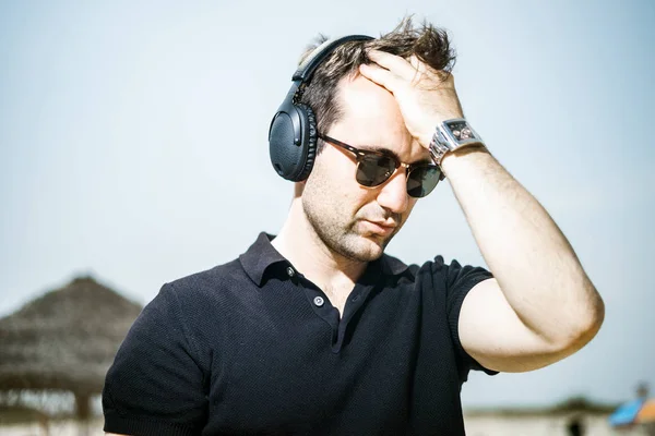Φορώντας Γυαλιά Ηλίου Και Παρακολουθήστε Απολαμβάνοντας Μουσική Στα Ακουστικά Του — Φωτογραφία Αρχείου