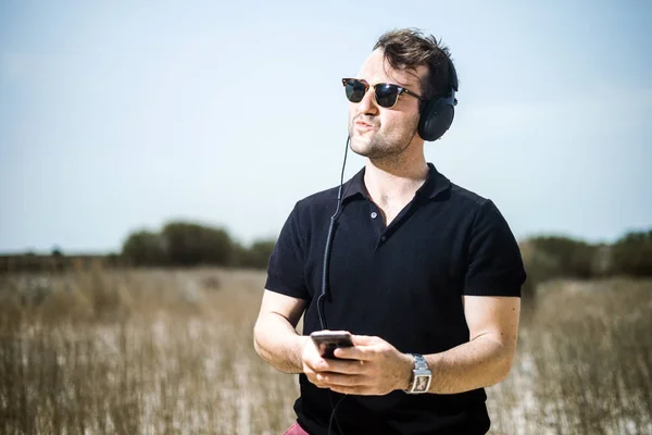Joven Guapo Tocando Música Desde Teléfono Inteligente Sus Auriculares —  Fotos de Stock