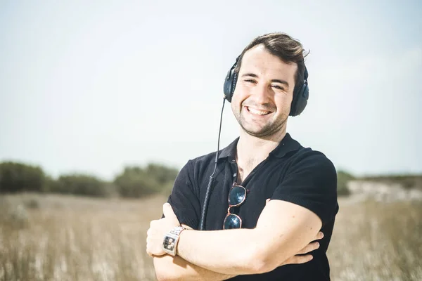 Jovem Homem Atraente Vestindo Preto Apreciando Música Seus Fones Ouvido — Fotografia de Stock