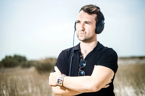 Jovem Homem Atraente Vestindo Preto Apreciando Música Seus Fones Ouvido — Fotografia de Stock