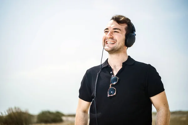 Jovem Homem Atraente Vestindo Preto Apreciando Música Seus Fones Ouvido — Fotografia de Stock