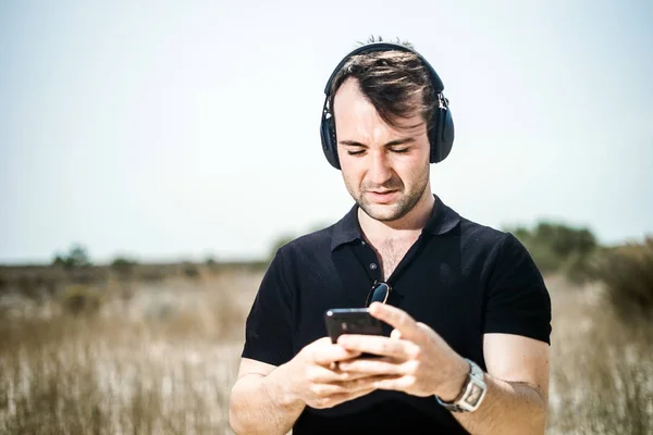 Joven Moda Tocando Música Desde Teléfono Inteligente Sus Auriculares —  Fotos de Stock