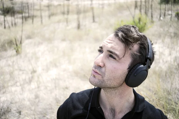 Jovem Homem Atraente Vestindo Preto Apreciando Música Seus Fones Ouvido — Fotografia de Stock