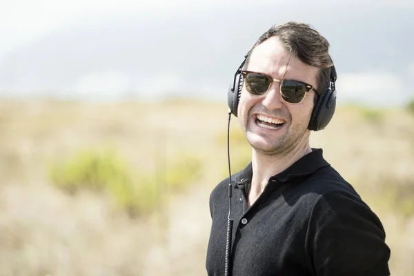 Joven Hombre Atractivo Con Gafas Sol Disfrutando Música Sus Auriculares — Foto de Stock