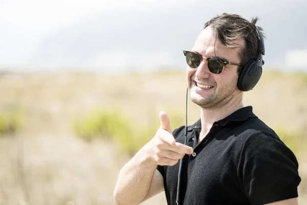 Aantrekkelijke Jongeman Dragen Zonnebril Hoofdtelefoon Wijzen Camera — Stockfoto