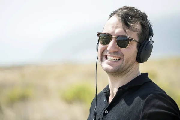 Jovem Homem Atraente Usando Óculos Sol Desfrutando Música Seus Fones — Fotografia de Stock