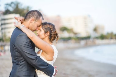 Gelin ve damat birbirine sahilde sarılma